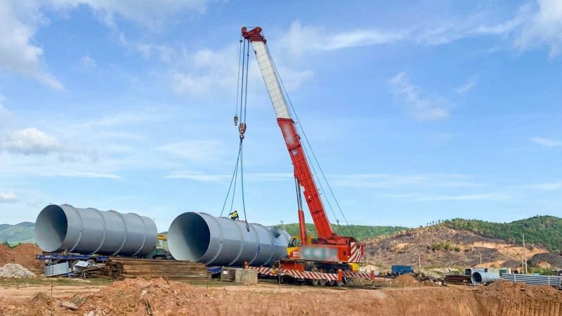 Dùng cẩu chuyên dụng bánh lốp nâng hạ ống thép cỡ lớn