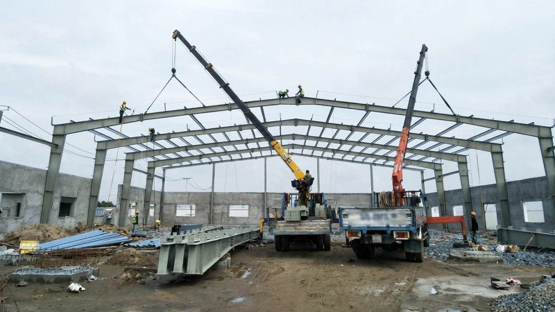 Dùng 2 xe cẩu tự hành cùng nâng cấu kiện thép dựng nhà xưởng