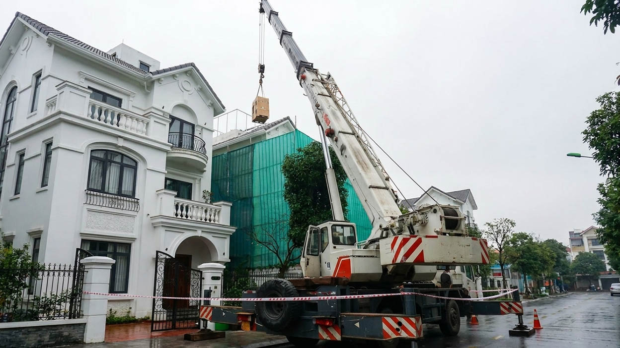 Dùng cẩu chuyên dụng nâng cục nóng điều hòa lên tầng mái