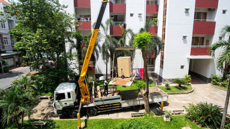 Dùng cẩu tự hành nâng tủ lạnh lên tầng cao của chung cư