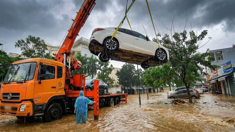 Dùng dây đai vải mềm buộc vào bánh xe rồi nâng xe lên bằng cẩu