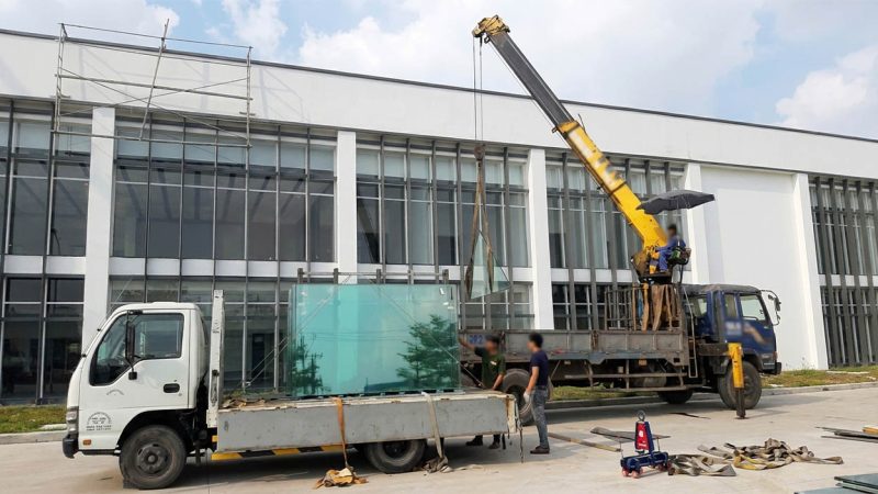 Dùng xe cẩu tự hành vừa chở kính vừa hỗ trợ lắp đặt