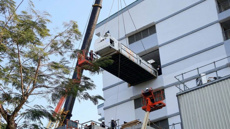 Dùng xe cẩu nâng máy nguyên chiếc vào nhà máy qua cửa ban công